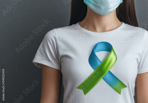 Woman Wearing Ribbon Symbol on Shirt with Protective Face Mask photo