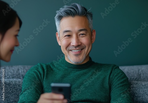 Smiling Man with Smartphone Enjoys Relaxed Moment at Home photo