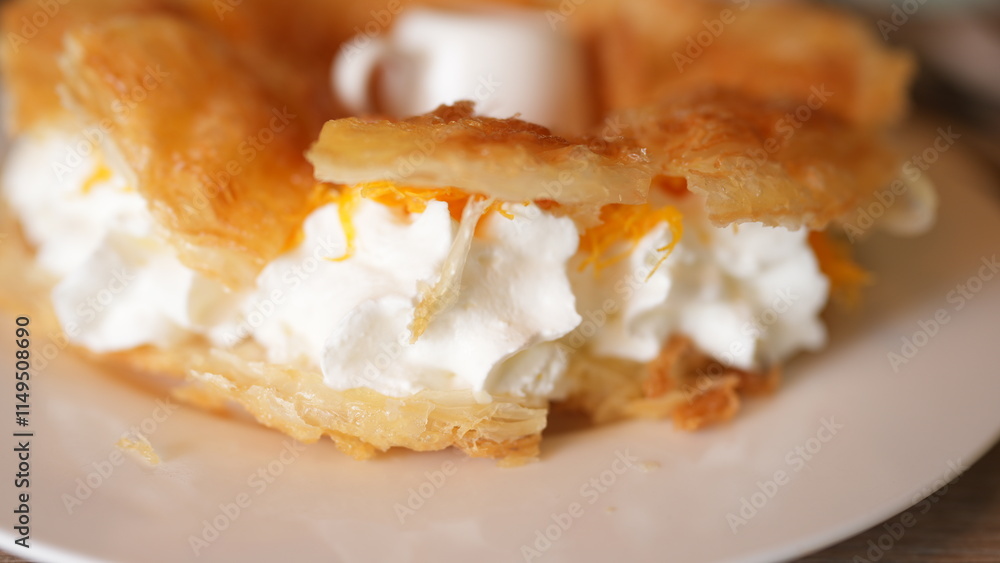 Delicious Creamy Pastry with Whipped Cream and Orange Garnish