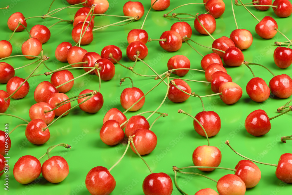 Cherries with green stems, positioned against a green. Cherries with green stems, positioned against a green.