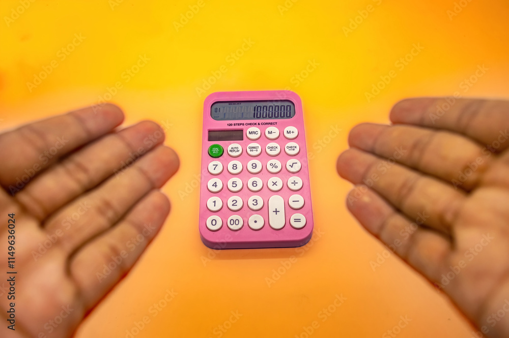 A pink calculator displaying 1000000 on its screen is held between two hands against a vibrant yellow orange background A pink calculator displaying 1000000 on its screen is held between two hands against a vibrant yellow orange background