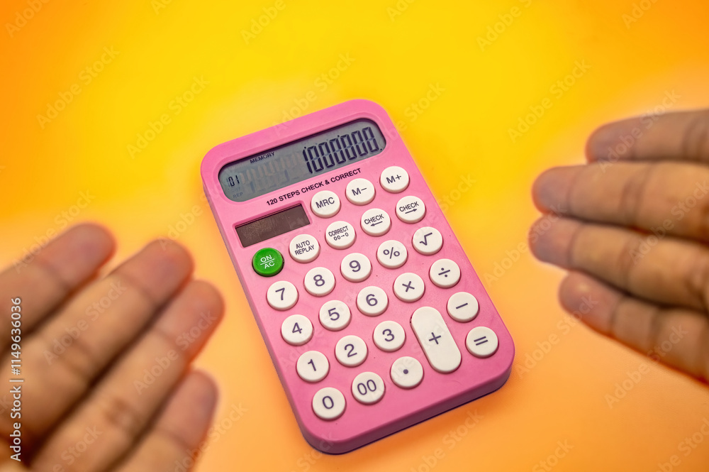 A pink calculator displaying 1000000 on its screen is held between two hands against a vibrant yellow orange background A pink calculator displaying 1000000 on its screen is held between two hands against a vibrant yellow orange background
