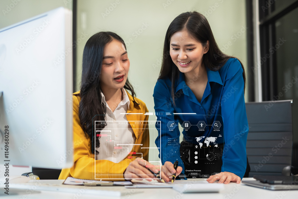 Fototapeta premium Two young Asian businesswoman discuss project manager working and update tasks and chart scheduling.