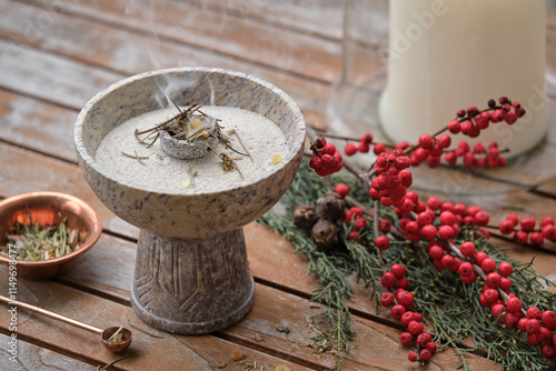 Censer with glowing charcoal and aromatic incense (frankincense, copal, spruce needles) on a wooden table. Shot outdoors on a cold winter morning. photo