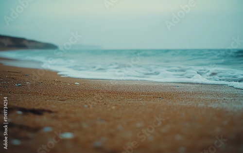 Closeup of sandy beach with a gently blurred ocean background, evoking a sense of calm and relaxation by the sea photo