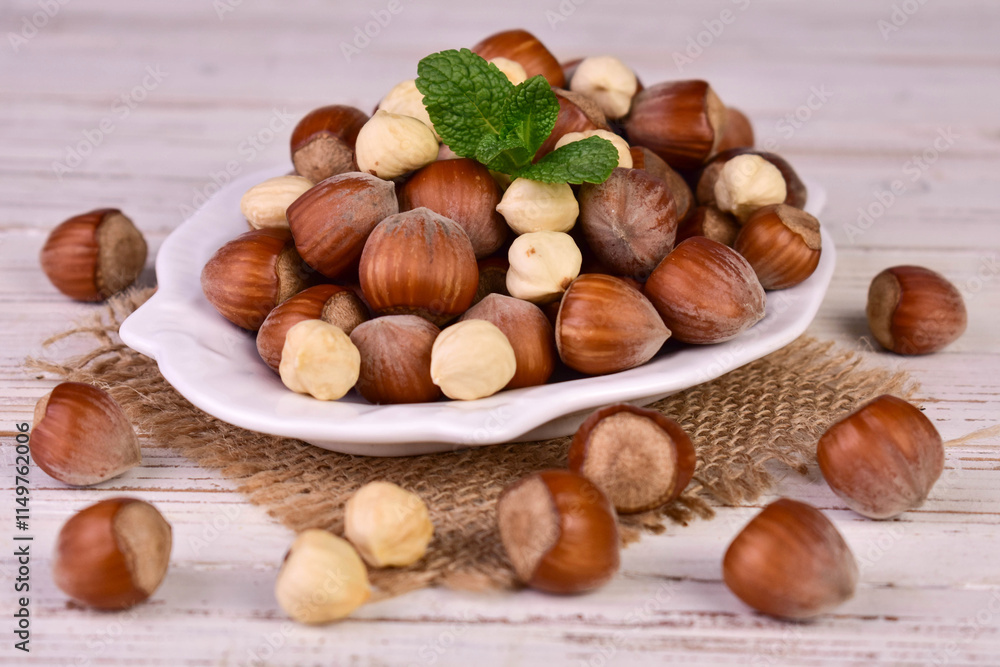 Hazelnuts in a plate on a white background.Close-up.
Hazelnuts in a plate on a white background.Close-up.