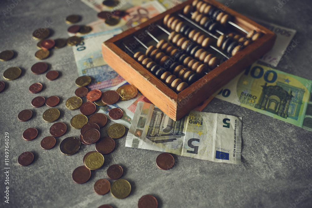 Man counting money on gray table with abacus and euro banknotes Man counting money on gray table with abacus and euro banknotes