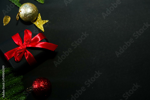 Season's greetings scene.Share your warm wishes with this image idea.view of magnificent giftbox with ribbon, sparkling ornaments, frosty fir, ball, cone on black backdrop, ready for personalized ad
 photo