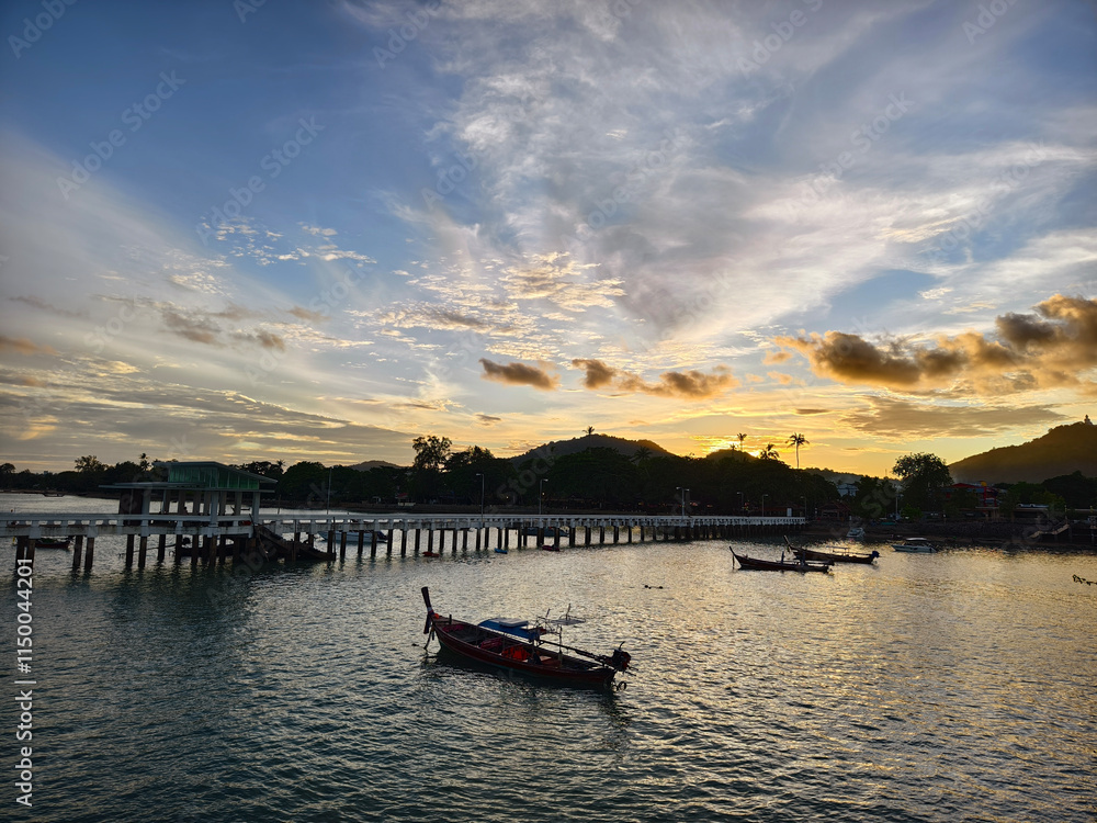 Fototapeta premium A beautifully serene view of a stunning sunset with fishing boats