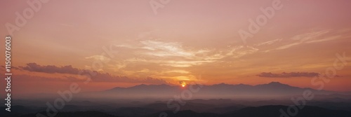 a breathtaking sunset painting the sky with warm hues, casting a golden glow over distant mountains and creating a tranquil atmosphere. The sun peeks through the clouds. wallpaper banner background