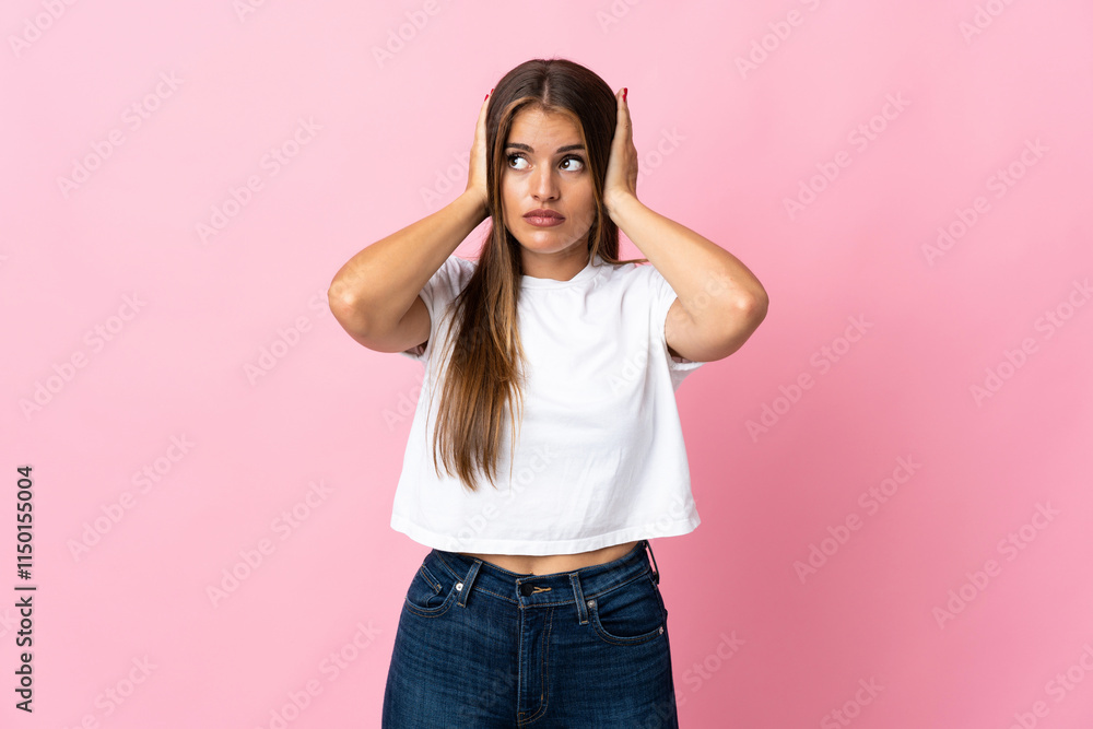 Young Uruguayan woman isolated on pink background frustrated and covering ears Young Uruguayan woman isolated on pink background frustrated and covering ears