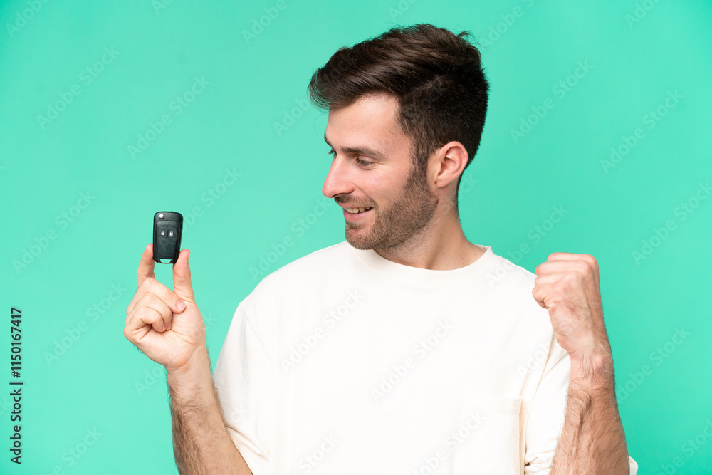 Young caucasian man holding car keys isolated on green background celebrating a victory Young caucasian man holding car keys isolated on green background celebrating a victory