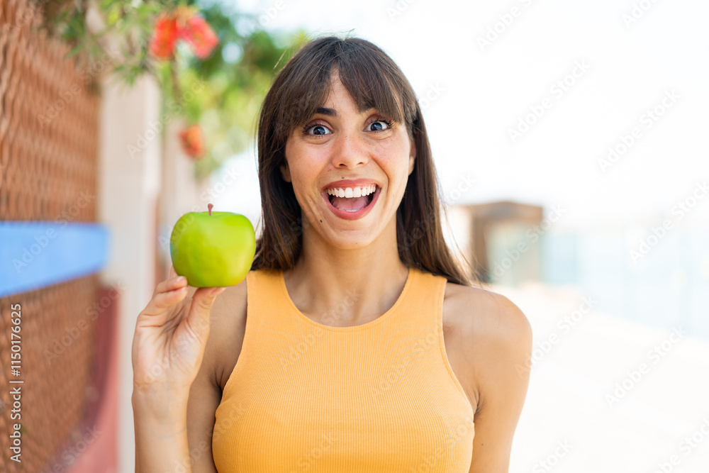 Young woman with an apple at outdoors with surprise and shocked facial expression Young woman with an apple at outdoors with surprise and shocked facial expression