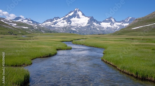 A serene landscape featuring a winding river surrounded by lush green grass and majestic snow-capped mountains under a clear blue sky.