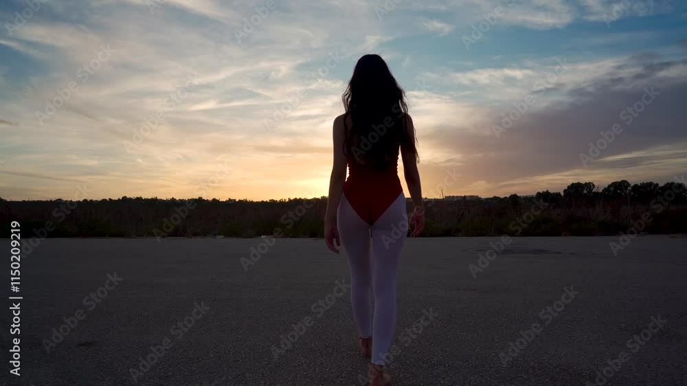 Chica bailarina de danza clásica anda por una pista de aterrizaje hacia la puesta de sol y realiza movimientos bonitos y elegantes de baile como conceptos de viajes, arte y energía.