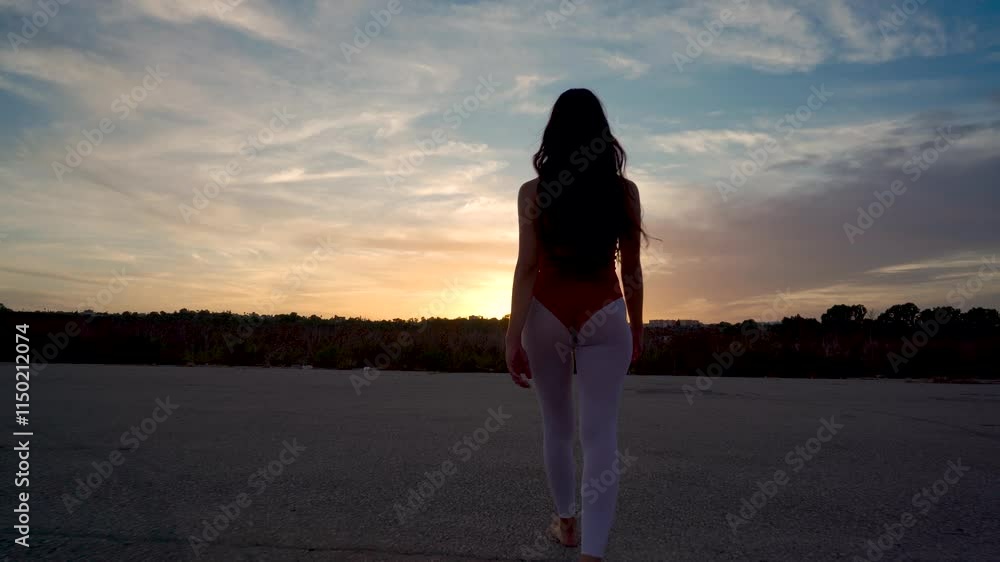 Chica bailarina de danza clásica anda por una pista de aterrizaje hacia la puesta de sol, se gira y realiza movimientos bonitos y elegantes de baile como conceptos de viajes, arte y energía.