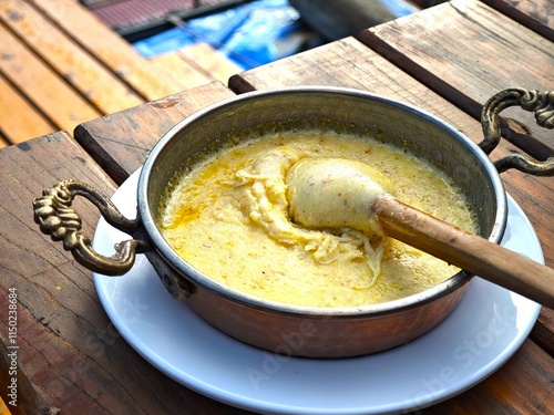 Kuymak or muhlama is a traditional dish from the Black Sea region of Türkiye made with melted cheese, butter, and cornmeal, cooked in an iron skillet or sahan photo