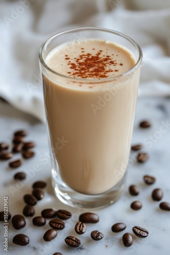 Refreshing cold brew coffee with ice and coffee beans on marble countertop