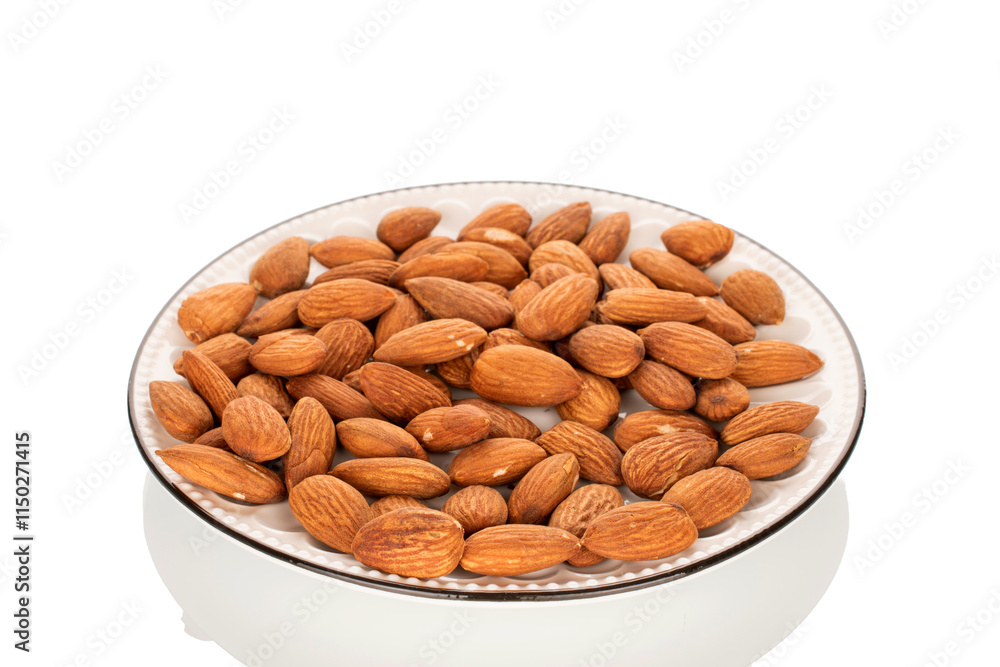 Fragrant roasted almonds in a ceramic saucer, close-up, isolated on a white background. Fragrant roasted almonds in a ceramic saucer, close-up, isolated on a white background.