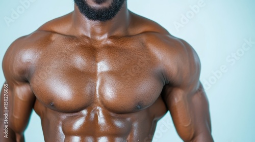 A striking shot of a man’s shiny torso, showcasing his strong and defined muscles under brilliant lighting, symbolizing physical excellence and athletic commitment. photo