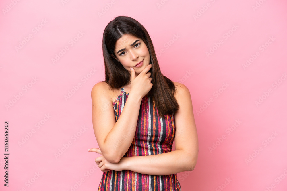 Young Brazilian woman isolated on pink background having doubts Young Brazilian woman isolated on pink background having doubts