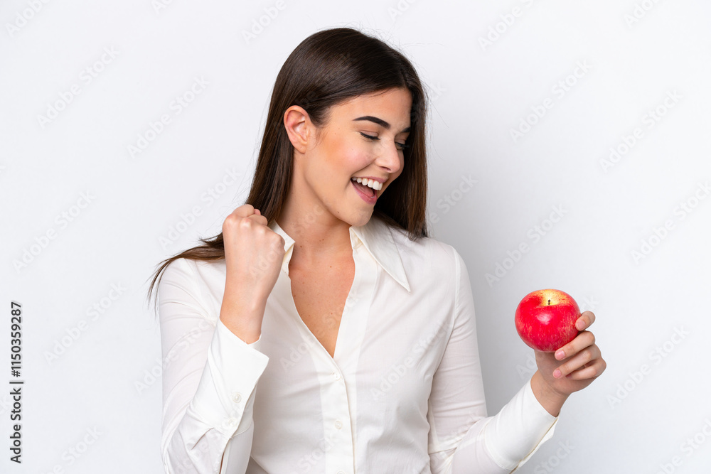 Young Brazilian woman with an apple isolated on white background celebrating a victory Young Brazilian woman with an apple isolated on white background celebrating a victory