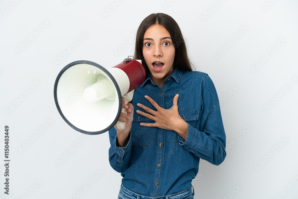Young French girl isolated on white background shouting through a megaphone with surprised expression Young French girl isolated on white background shouting through a megaphone with surprised expression
