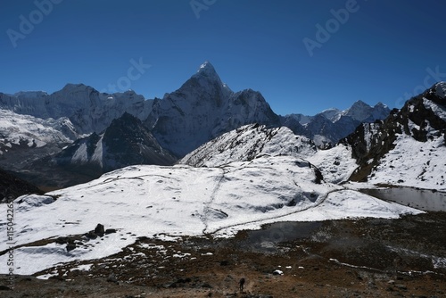 Amazing view on trekking from Dingboche to Lobuche through Kongma La Pass 5535 m. Little silhouette of trekking person on snow. Ama Dablam Mount in background. Everest Base Camp trek. Himalayas, Nepal photo