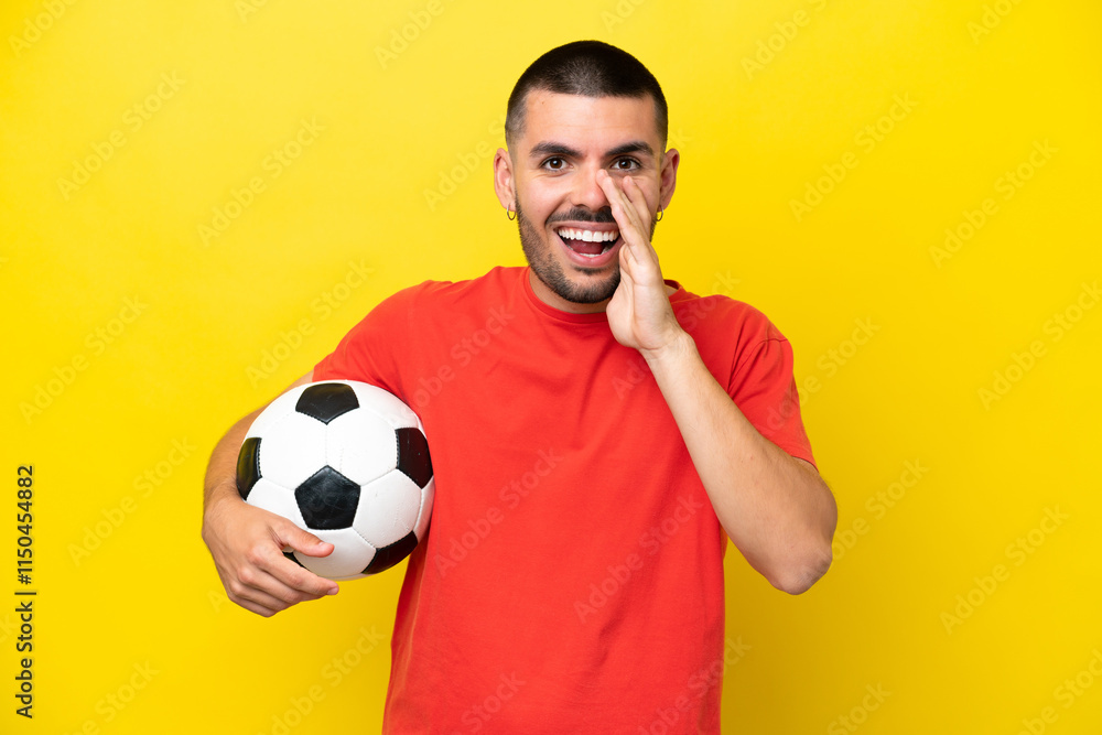 Young caucasian man playing soccer isolated on yellow background shouting with mouth wide open Young caucasian man playing soccer isolated on yellow background shouting with mouth wide open