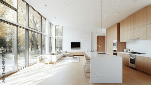 Obraz na płótnie Light-filled modern kitchen with light wood cabinets, a white island, and large windows looking out to trees. w salonie