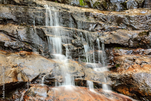 A waterfall is flowing down a rocky cliff