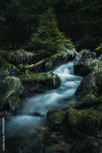 A picturesque waterfall is beautifully surrounded by rocks and tall trees