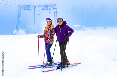 Obraz na płótnie Two father and daughter skiers enjoying a beautiful day on the slopes surrounded by nature and snow w salonie