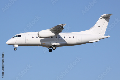 A Small White Jet Airplane arriving in bright evening light photo