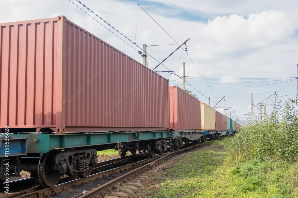 Freight transport: a train of flatcars carrying containers travels along the railway Freight transport: a train of flatcars carrying containers travels along the railway