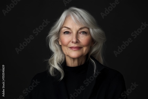 Portrait of an elegant older woman with silver hair against a dark background showcasing beauty and confidence