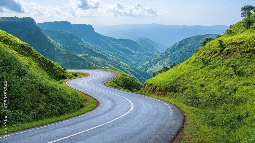 Fototapeta premium Winding mountain road through lush green valley.