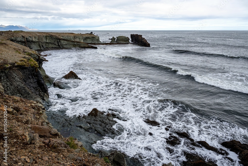 Scenic view of ocean waves crashing against the Vattarnes Sea cliffs during daytime in East Iceland Scenic view of ocean waves crashing against the Vattarnes Sea cliffs during daytime in East Iceland