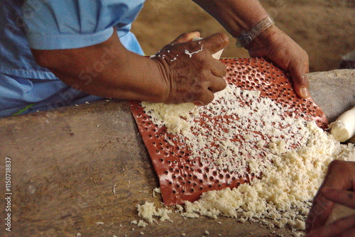 Hands of a Siona woman making yucca bread in an outdoor kitchen, in the village of Puerto Bolivar, in the Cuyabeno Wildlife Reserve, outside of Lago Agrio, Ecuador photo