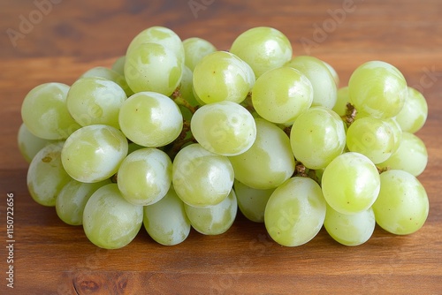 Green grapes arranged on a wooden surface with leaves in a lush garden settin...