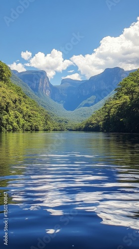 Lush river surrounded by mountains in a vibrant green landscape during daylig...