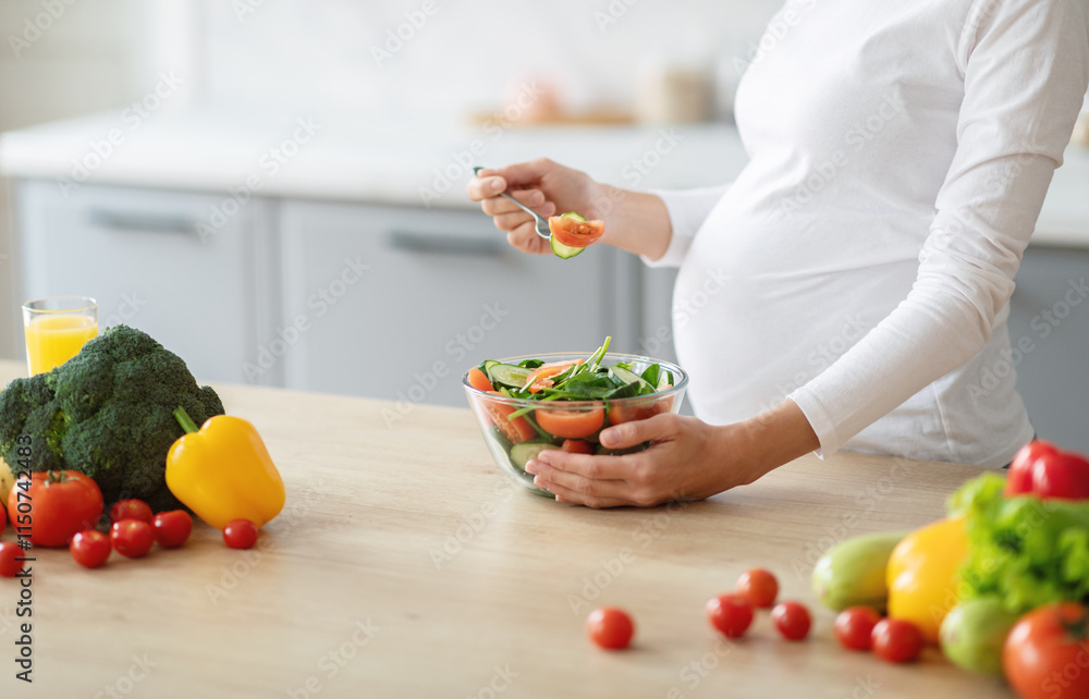 A pregnant woman enjoys preparing a healthy salad in a bright kitchen. Fresh vegetables like tomatoes, broccoli, and bell peppers are arranged artistically. A pregnant woman enjoys preparing a healthy salad in a bright kitchen. Fresh vegetables like tomatoes, broccoli, and bell peppers are arranged artistically.