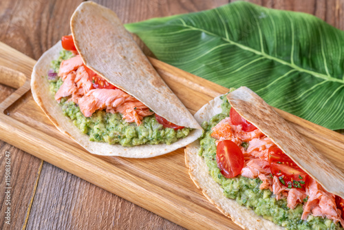 Salmon Tacos with Guacamole and Tomatoes on Rustic Table