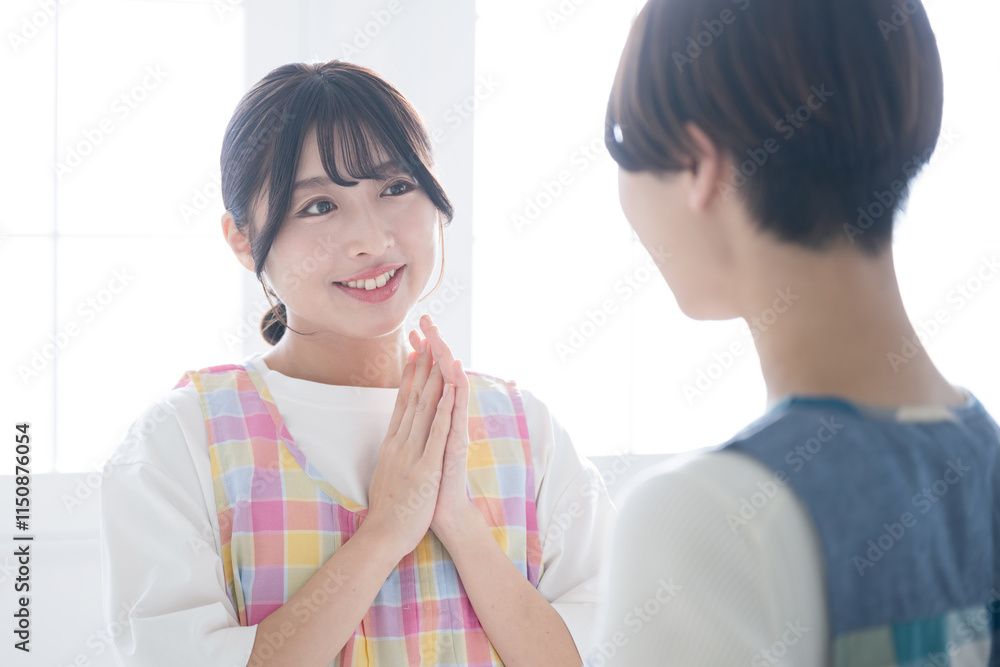 会話、コミュニケーションするエプロンを着た主婦や保育士などの女性の2人のクローズアップ 後輩の指導や社員教育や社員研修などに 会話、コミュニケーションするエプロンを着た主婦や保育士などの女性の2人のクローズアップ 後輩の指導や社員教育や社員研修などに