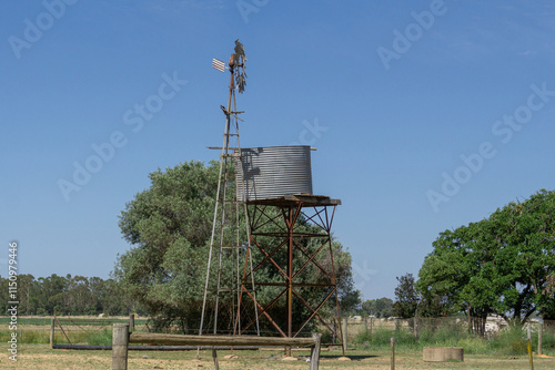 Elevated Galvanised Metal Tank elevated on a stand for storage of Freshwater with a windmill used to pump water to the tank