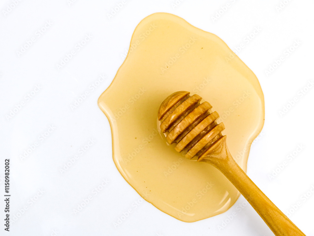 Natural honey dripping from dipper on white background Natural honey dripping from dipper on white background
