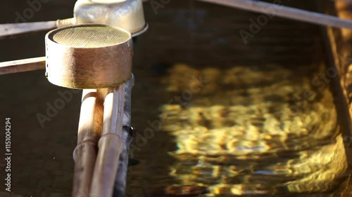 神社の手水舎の日の当たる柄杓ときらめく手水　フィックス撮影