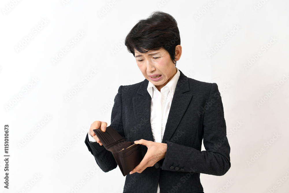 財布を見ながら困るスーツ姿の中高年の女性
