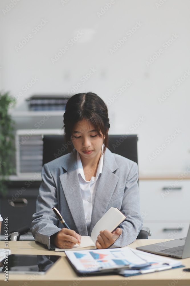 Successful Asian businesswoman smiling using laptop computer and holding coffee cup at office. Confident Asia businesswoman sitting happily in the office. Successful Asian businesswoman smiling using laptop computer and holding coffee cup at office. Confident Asia businesswoman sitting happily in the office.