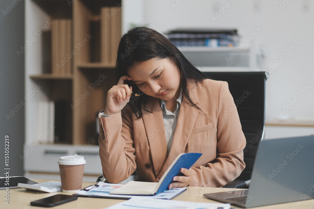 Charming asian businesswoman sitting working on laptop in office. Charming asian businesswoman sitting working on laptop in office.